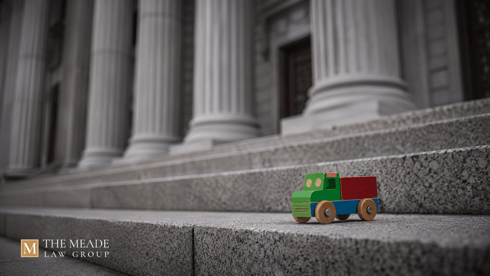 Colorful child's toy on courthouse steps representing child endangerment laws, penalties, and legal defense in Ohio.