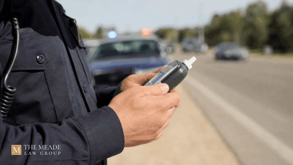 An officer holding a breathalyzer at an Ohio traffic stop, illustrating breathalyzer refusal laws