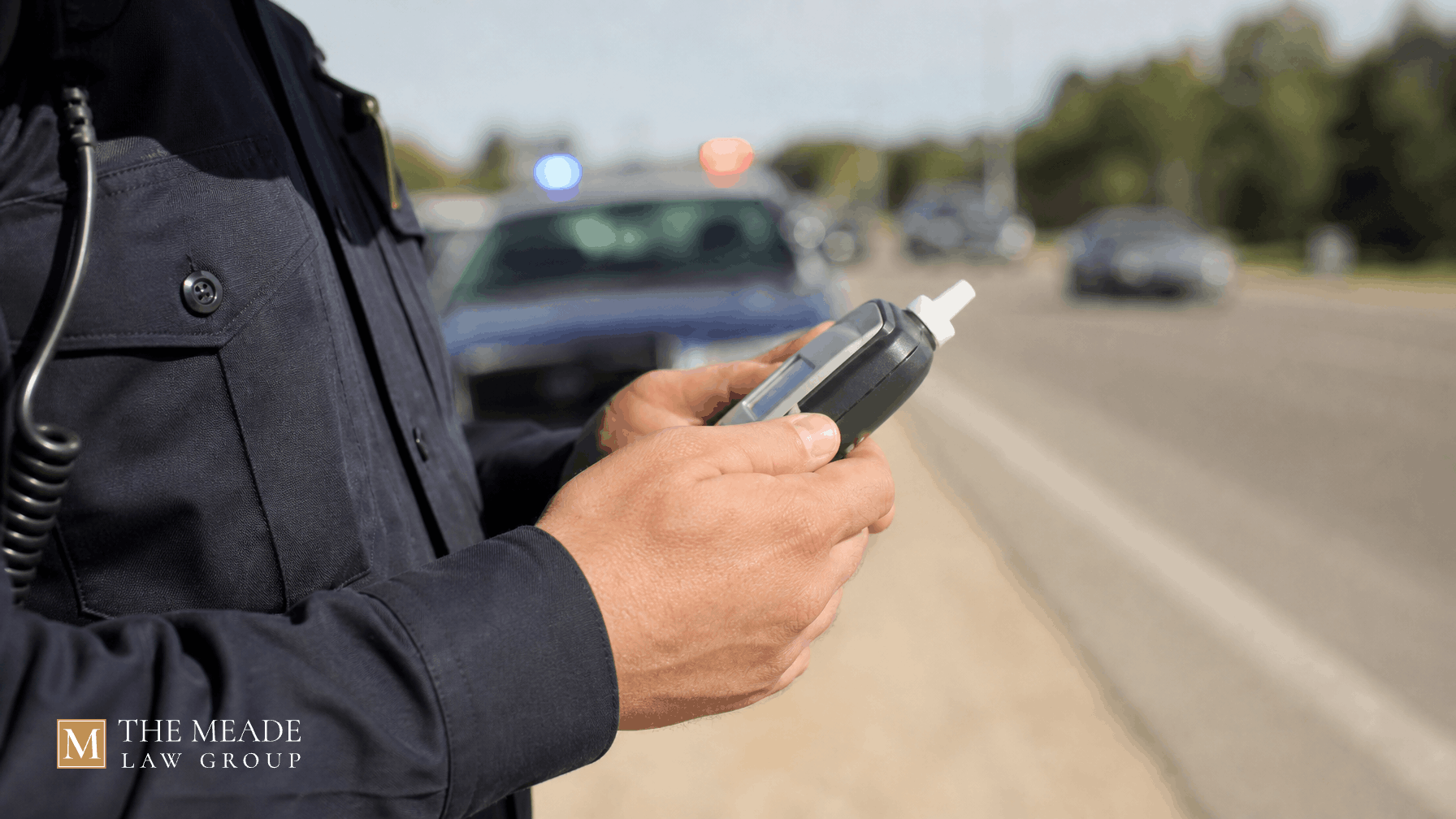An officer holding a breathalyzer at an Ohio traffic stop, illustrating breathalyzer refusal laws