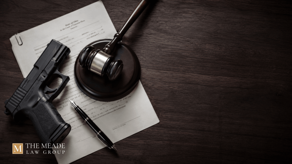 A handgun, judge's gavel, court documents, and fountain pen on a dark wooden surface, representing Ohio weapons under disability charges.