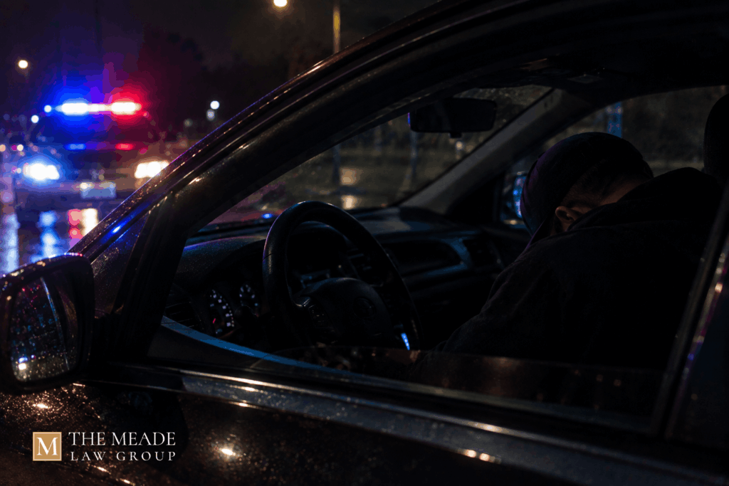 Person asleep in the driver's seat of a parked car at night, illustrating an Ohio physical control charge.